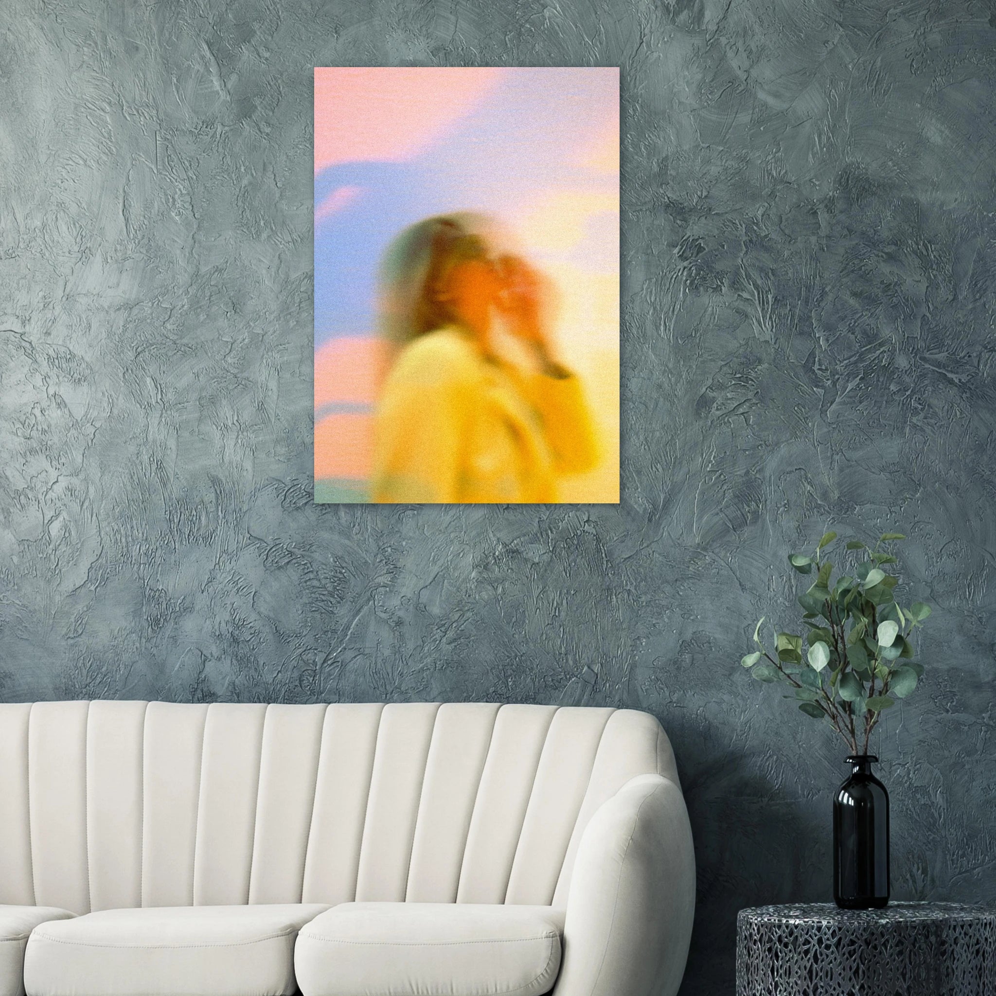 Abstract artwork poster of a woman in a yellow dress on a textured gray wall above a white sofa.