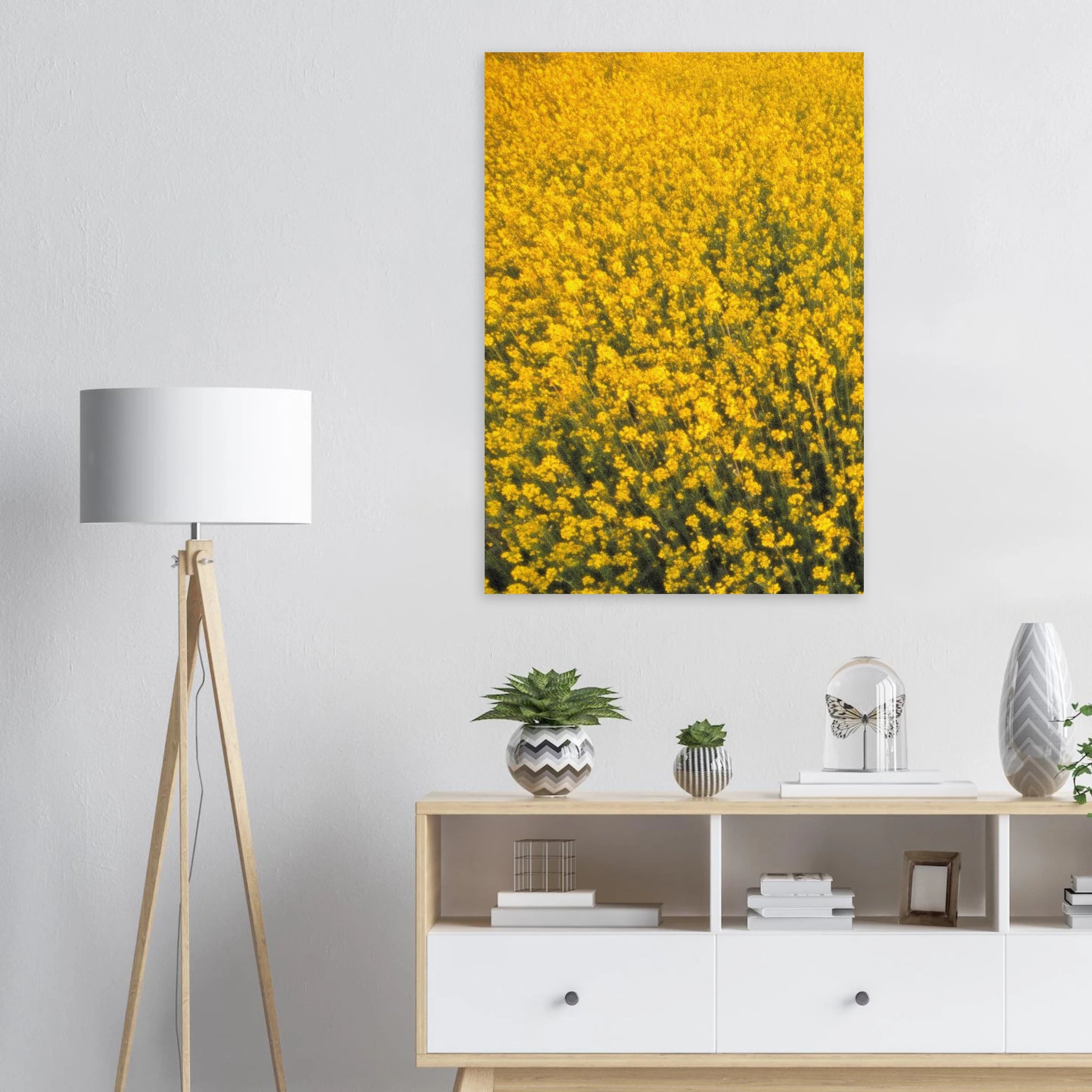 Yellow floral artwork poster on a wall above a white console table with decorative items.